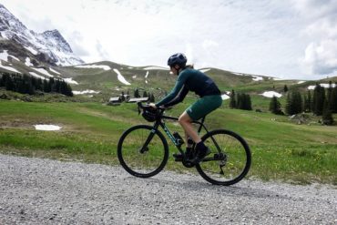 Frau mit Gravelbike auf Schotterstrasse