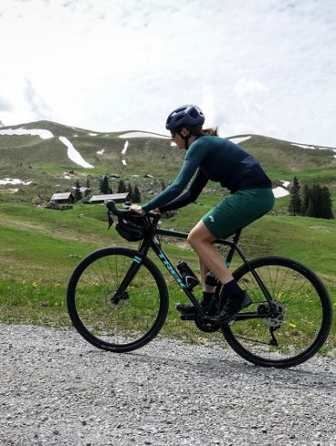 Frau mit Gravelbike auf Schotterstrasse