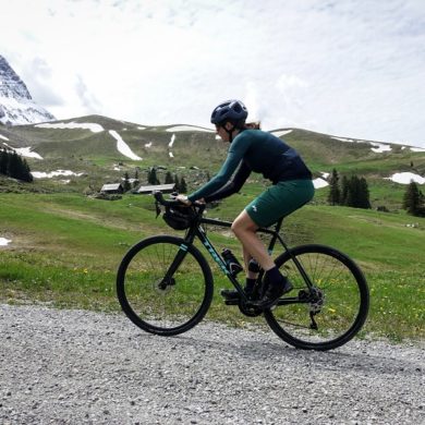 Frau mit Gravelbike auf Schotterstrasse