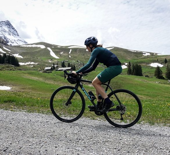 Frau mit Gravelbike auf Schotterstrasse